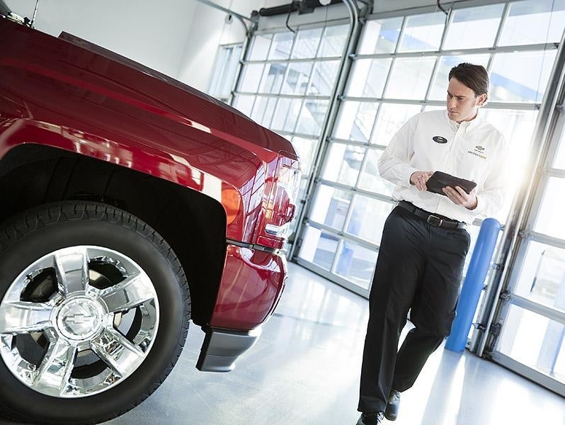 A service expert, doing an inspection on a vehicle