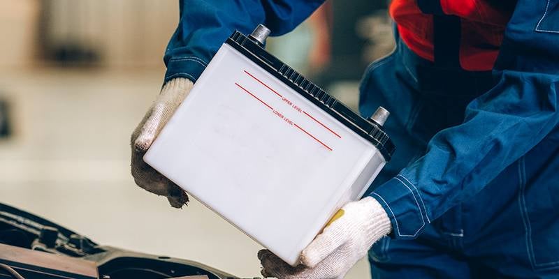 James Wood Buick GMC in Decatur TX technician placing a new battery in an engine