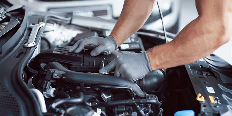 James Wood Buick GMC in Decatur TX close up of technician with hands on an engine